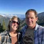 Man and woman smiling with mountain side in the background